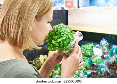 Woman with basil leaves in the store - Shutterstock ID 2255003805