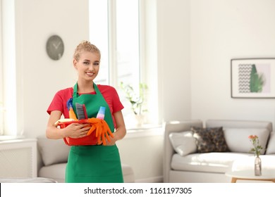 Woman With Basin And Cleaning Supplies In Living Room