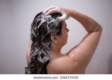 Woman bathing in clean bathroom, enjoying water and soap suds in bathtub. - Shutterstock ID 2366714145