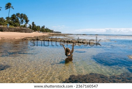 woman bathing in the sea and enjoying the sun on the beach beautiful day with blue sky