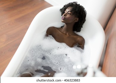 Woman bathing in a tub full of foam