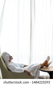 Woman In Bathrobe After Shower Relax In Hotel Room Near The Panorama Window.