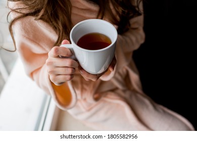 バスローブに熱いお茶を持つ女性。 気分が悪い。  