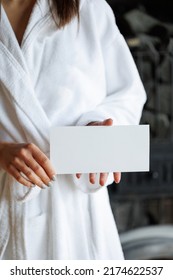 Woman In Bathrobe Holding An Empty Spa Gift Card For Visits