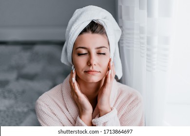 Woman in a bathrobe relaxes after bath procedures in his room. Morning skin care routine. Stay at home while quarantined to avoid coronavirus.
