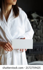 Woman In Bathrobe With Spa Gift Voucher In Hands