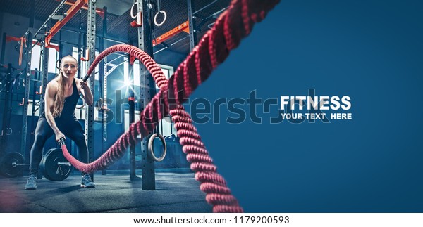Woman with battle rope battle ropes exercise in\
the fitness gym. gym, sport, rope, training, athlete, workout,\
exercises concept