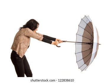 Woman Battling With Her Umbrella Holding On Tightly As It Is Blown Away By The Wind, Three Quarter Studio Portrait Isolated On White