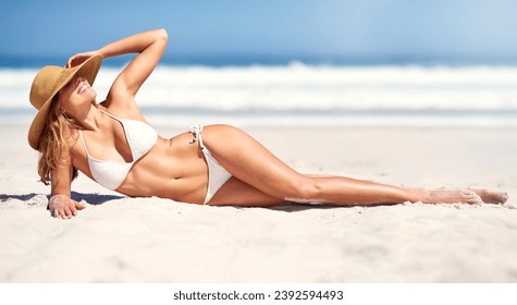 Woman, beach and bikini on sun tanning on holiday vacation, summer relax or ocean outdoor peace. Female person, hat and nature for confidence in clean air for weekend travel, water swimsuit in Bali - Powered by Shutterstock