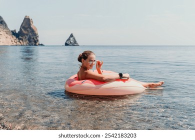 Woman, Beach, Float - Happy Woman Relaxing on a Pink Inflatable Float in the Sea Near Rocky Coastline - Powered by Shutterstock