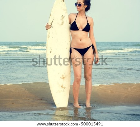 Similar – Brunette surfer woman in bikini standing with surfboard