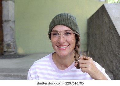 Woman Bearing Beanie, Retro Eyeglasses And Braided Hair 