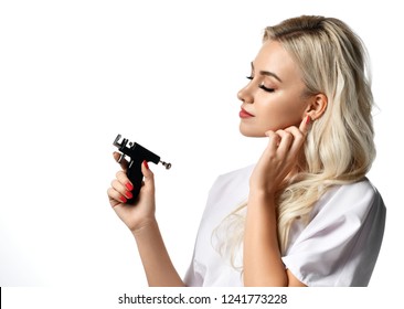 Woman Beautician Cosmetologist Hold Ear Piercing Gun Looking At The Corner Isolated On White Background