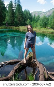 Woman At Beautiful Geyser Lake With Thermal Springs That Periodically Throw Blue Clay And Silt From The Ground. Altai Mountains, Russia