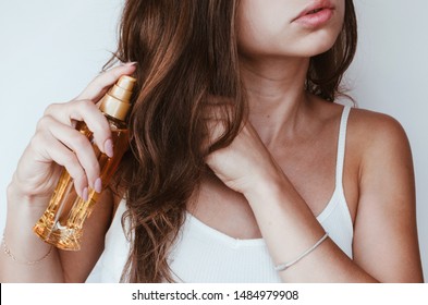 
a woman with beautiful hair holds hair oil. The concept of hair care