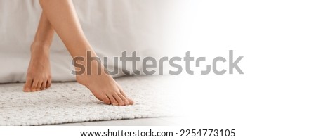 Woman with beautiful legs sitting on bed at home. Banner for design