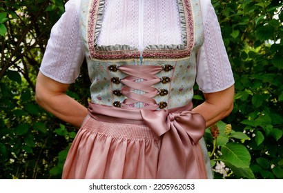 a woman in a beautiful traditional Bavarian or also Austrian dirndl dress (or Tracht) at the Bavarian October fest (Oktoberfest) (Munich, Bavaria, Germany)                                - Shutterstock ID 2205962053