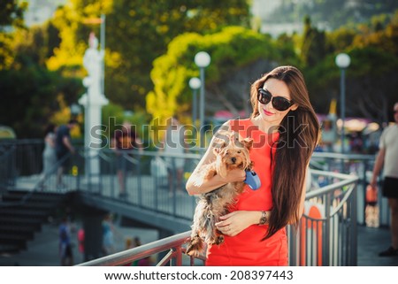 Woman beautiful young happy with long dark hair playing with small dog
