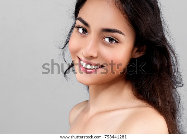 Woman beauty face portrait isolated on gray with healthy skin and white teeth smile. Studio shot.