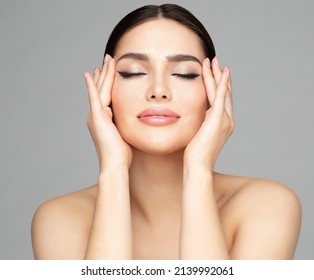 Woman Beauty Face. Women Skin Care And Make Up. Model With Closed Eyes Enjoying Facial Massage. Facelift Cosmetology Over Gray. Girl With Plump Lips And Perfect Eyeliner