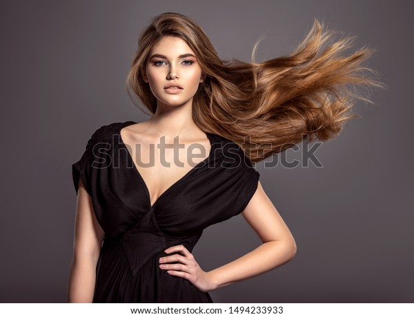 美しい長い茶色の髪の女性 青い目をした魅力的なモデルの美しい顔 白人女性の接写 魅力的なファッションモデル の写真素材 今すぐ編集