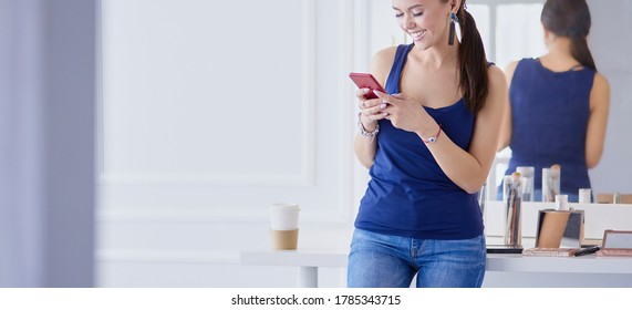 Woman beauty salon using and looking at mobile phone - Shutterstock ID 1785343715