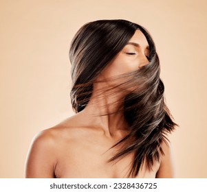 Woman, beauty and shake hair in studio for aesthetic shine, volume and smooth shampoo results. Indian female model, salon treatment and wind in hairstyle for growth, soft texture and cosmetic care