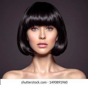 Woman with beauty short black hair - posing at studio. Fashion model with  straight hair. Fashion model at studio. Beautiful woman with a style  hairstyle. Closeup portrait of a fashion model.