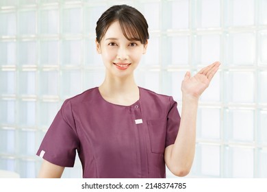 A woman in a beauty treatment salon or clinic uniform who poses as a guide