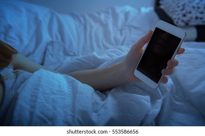 Woman In Bed Holding Smart Phone At Night Close Up, Blank Screen