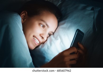 Woman In Bed With Phone In The Night