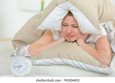 Woman In Bed With A Pillow Over Head