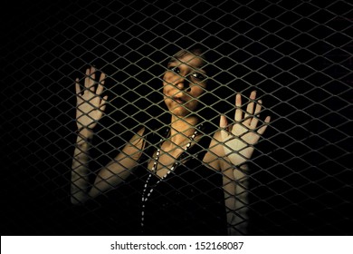 Woman behind a metal fence