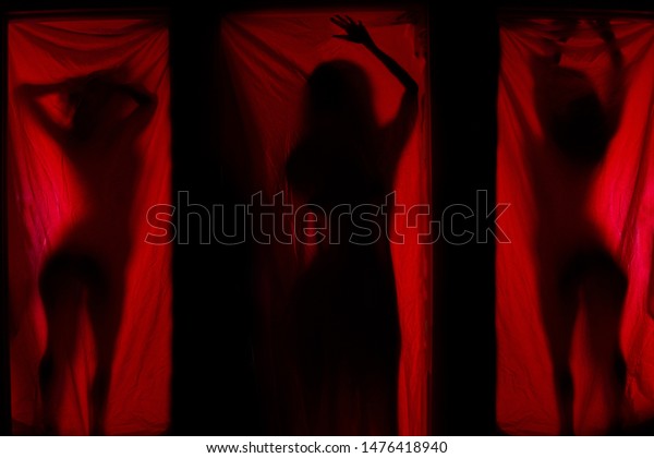 Woman behind\
red curtains. Prostitute or\
stripper