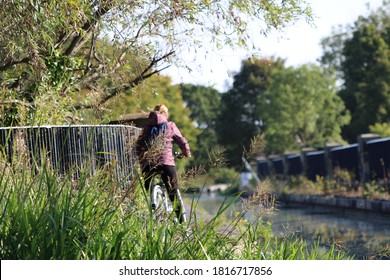 Woman Behind Tall Grass Cycling Along The Union Canal In Edinburgh