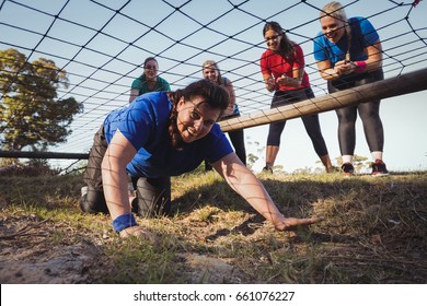 Woman being cheered bye her teammates during obstacle course training in the boot camp - Powered by Shutterstock