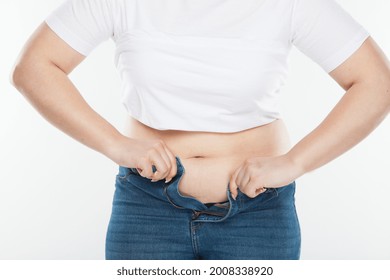 Woman With Belly Fat Getting Dressed Putting Pants On. Overweight Female Trying To Fasten Too Small Trousers Isolated. Weight Gain Diet Concept