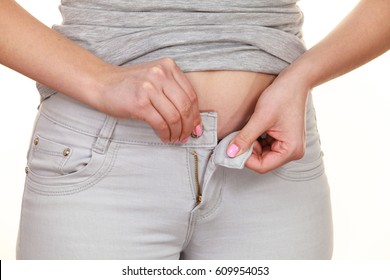 Woman With Belly Fat Getting Dressed Putting Pants On. Overweight Female Trying To Fasten Too Small Trousers Isolated. Weight Gain Diet Concept