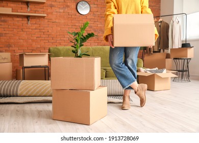 Woman with belongings in cardboard boxes on moving day