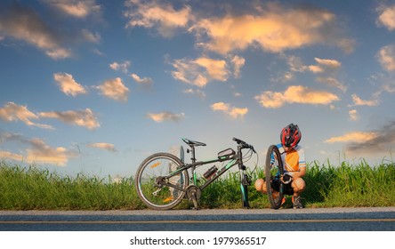 Woman Bicycle Cyclist In Trouble Of Front Tire Wheel Needs Repair And Adjusting By Herself On The Road
