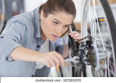 woman bicycle engineer is repairing a bike in the workshop - Powered by Shutterstock