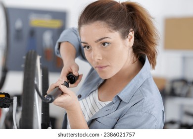 woman bicycle engineer is repairing a bike in the workshop - Powered by Shutterstock