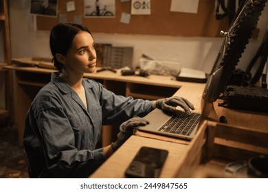 Woman bicycle mechanic is repairing a bike in the workshop, using laptop computer searching information. Bike service. Copy space - Powered by Shutterstock
