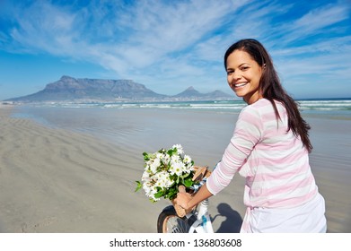 Woman With Bicycle On Beach In Cape Town, South Africa And Table Mountain