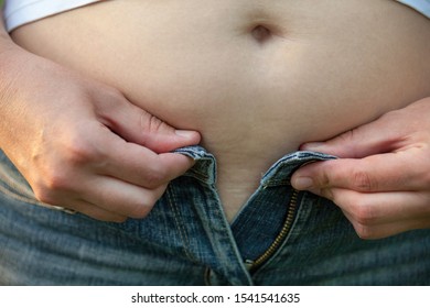 Woman With Big Belly. Jeans That Don't Fit Any More. 