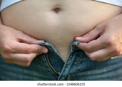 Woman With Big Belly. Jeans That Don't Fit Any More. 