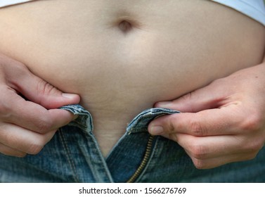 Woman With Big Belly. Jeans That Don't Fit Any More. 