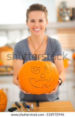 Woman with big scary pumpkin Jack-O-Lantern for Halloween. Closeup