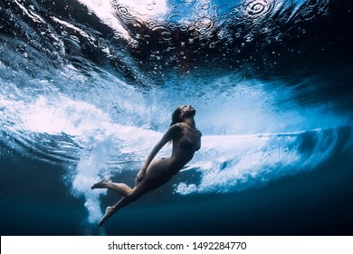 Woman in bikini dive without surfboard underwater with ocean wave. Duck dive under barrel wave - Shutterstock ID 1492284770