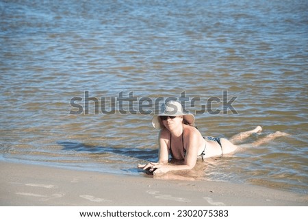 Woman in a bikini relaxing and bathing at the seaside. Taquari, Guaibim beach, Valenca, Bahia.